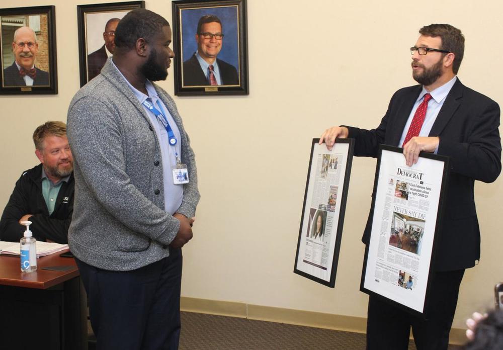 West Feliciana Parish School Superintendent Hollis Milton, right, presents Bains Lower Elementary principal Torrence Williams with framed copies of a St. Francisville Democrat article about the educator, who is leaving to join the staff of the Associated Professional Educators of Louisiana. Williams was one of several people honored during the School Board's Nov. 16 meeting.