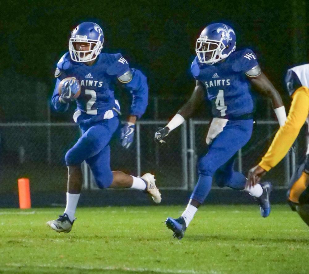 During a 2019 game, West Feliciana Saints Alten Franklin runs with the ball as running back Neno Lemay runs alongside.