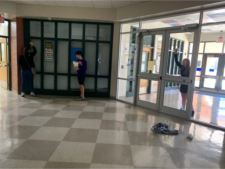Students clean the windows in the foyer 